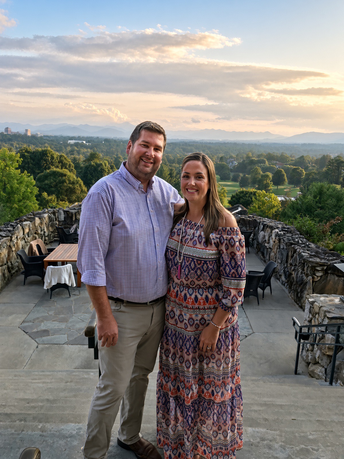 Bryan and Emily Dunleavy on a terrace overlooking the Upstate mountains at sunset